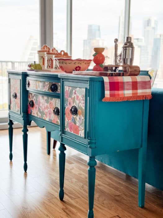 Styled as kitchen island – Teal sideboard buffet styled as a colorful kitchen island with dishes on top.