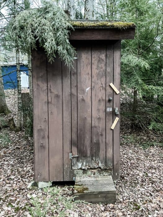 before photo of brown outhouse