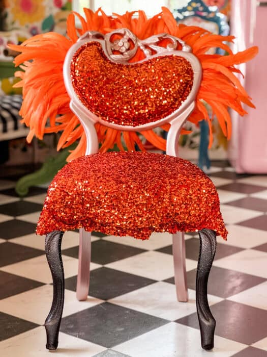 The Life of a Showgirl Chair in orange sequins and feathers named after Taylor Swifts newest album.
