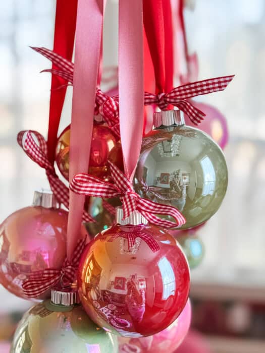 Small red gingham bow tied above each ornament for a festive cottage-style Christmas detail.