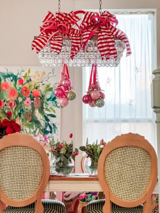 Full view of the dining room showing the Christmas chandelier decor, table setting, and colorful wallpaper.