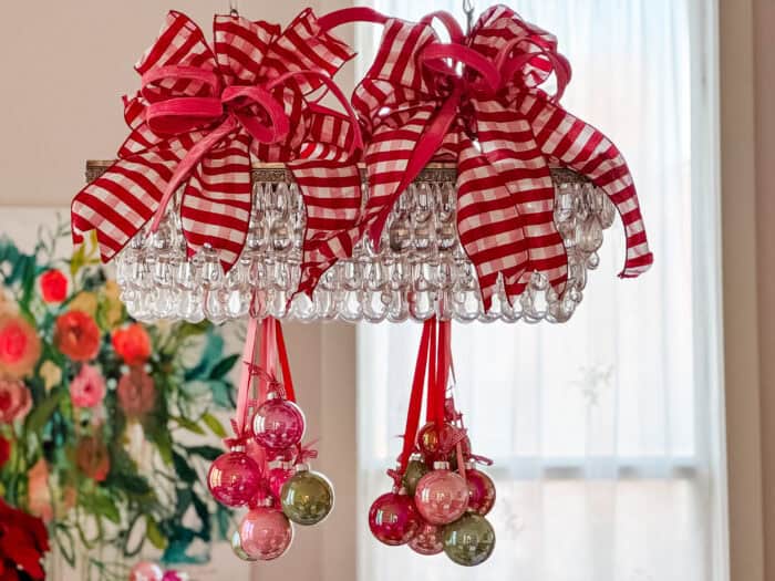 Oversized wired bows in pink and red gingham attached to the top of the chandelier for added holiday flair.