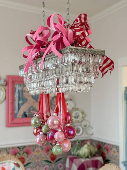 Oversized wired bows in pink and red gingham attached to the top of the chandelier for added holiday flair.