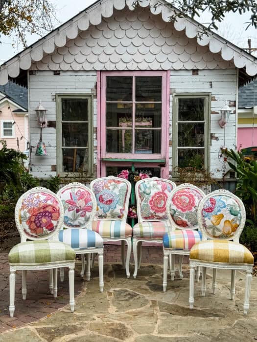A colorful set of 6 chairs with florals on top and a variety of patterned seats. 