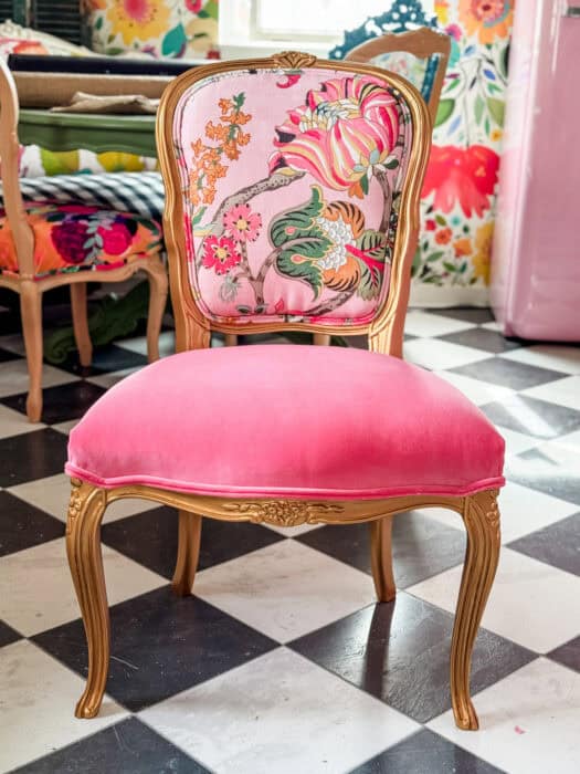 The after chair with a floral fabric and a velvet seat. The frame is painted gold. 