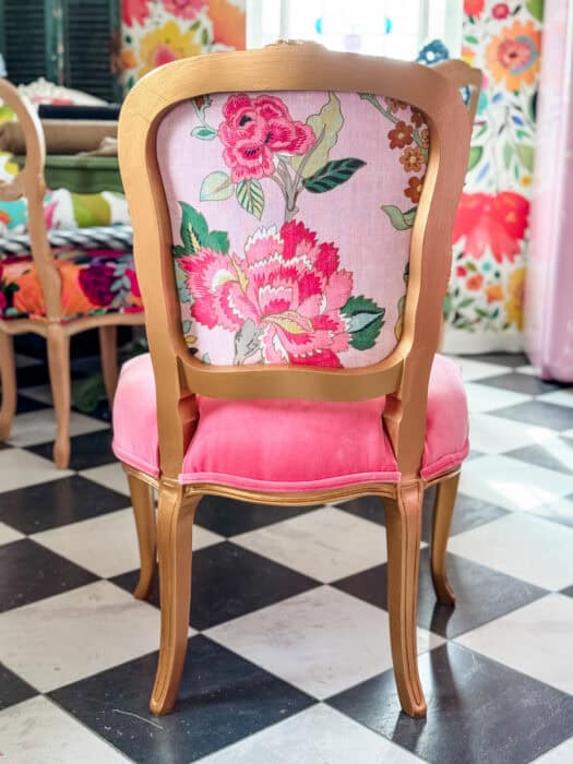 Gold chair with a floral fabric and pink velvet seat. 