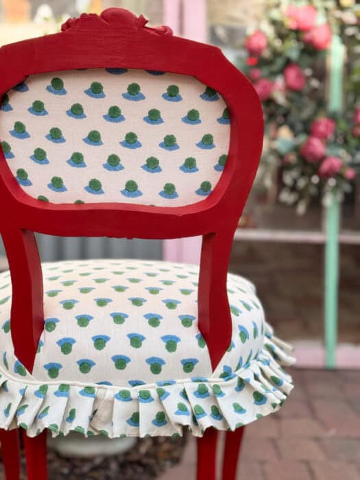Red painted chair with blue and green Molly Mahon fabric on it.