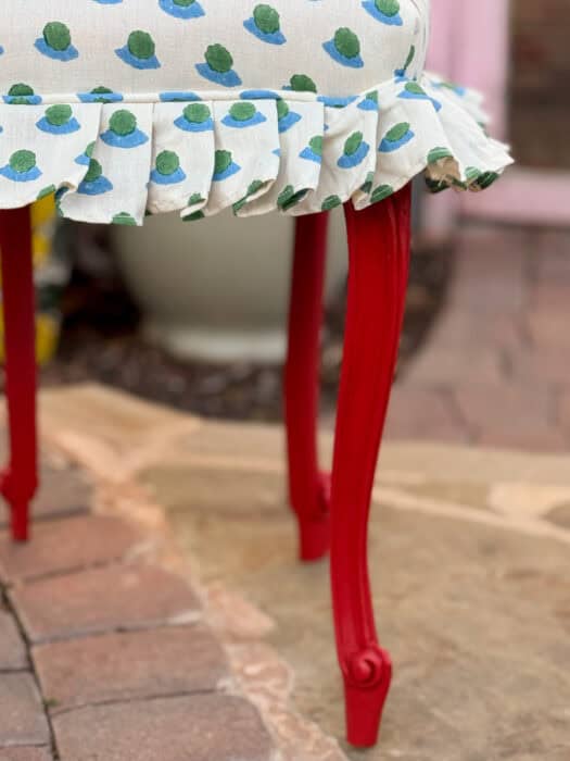 Picture of the red leg of the chair and a ruffled edge trim. 