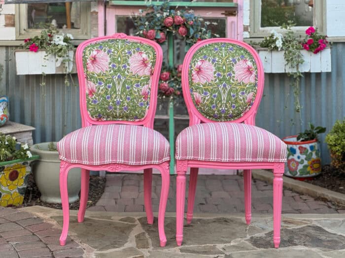 Two finished chairs showing the floral and striped fabric and the pink paint.