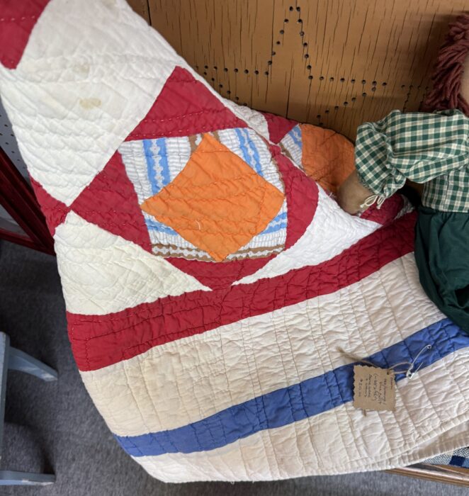 Quilt in white, red, blue and orange from an antique shop