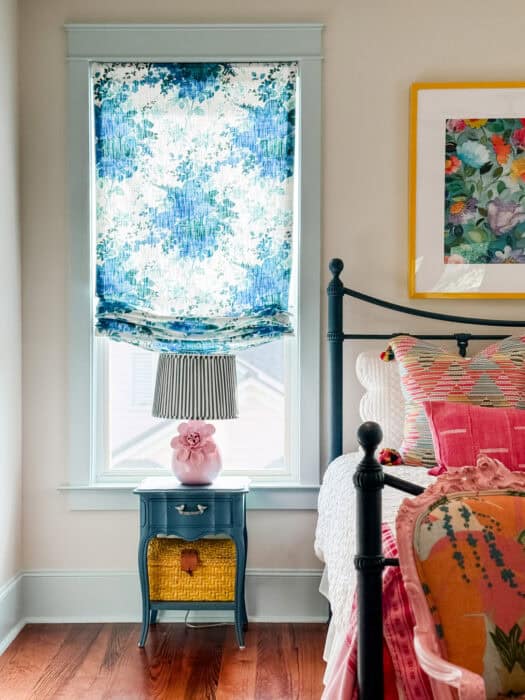 Picture of side table painted blue with a pink lamp and striped lampshade.