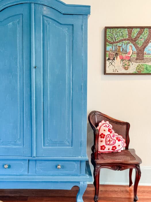 Blue Lagoon painted armoire next to a chair.