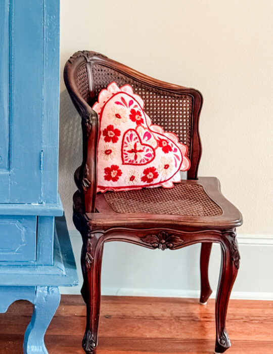 Small wood chair with heart pillow.