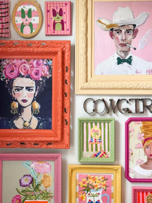 Frames and prints in a variety of colors hung on a wall. 