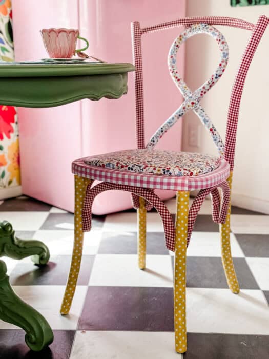 Picture of the finished chair at a table with a tea cup.