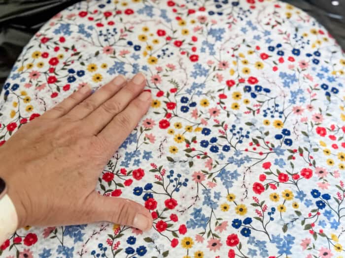 A chair seat showing how to smooth fabric out with your fingers