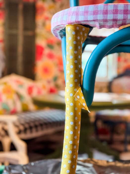 Fabric with excess around a chair leg, showing that you can cut it to fit as you work.